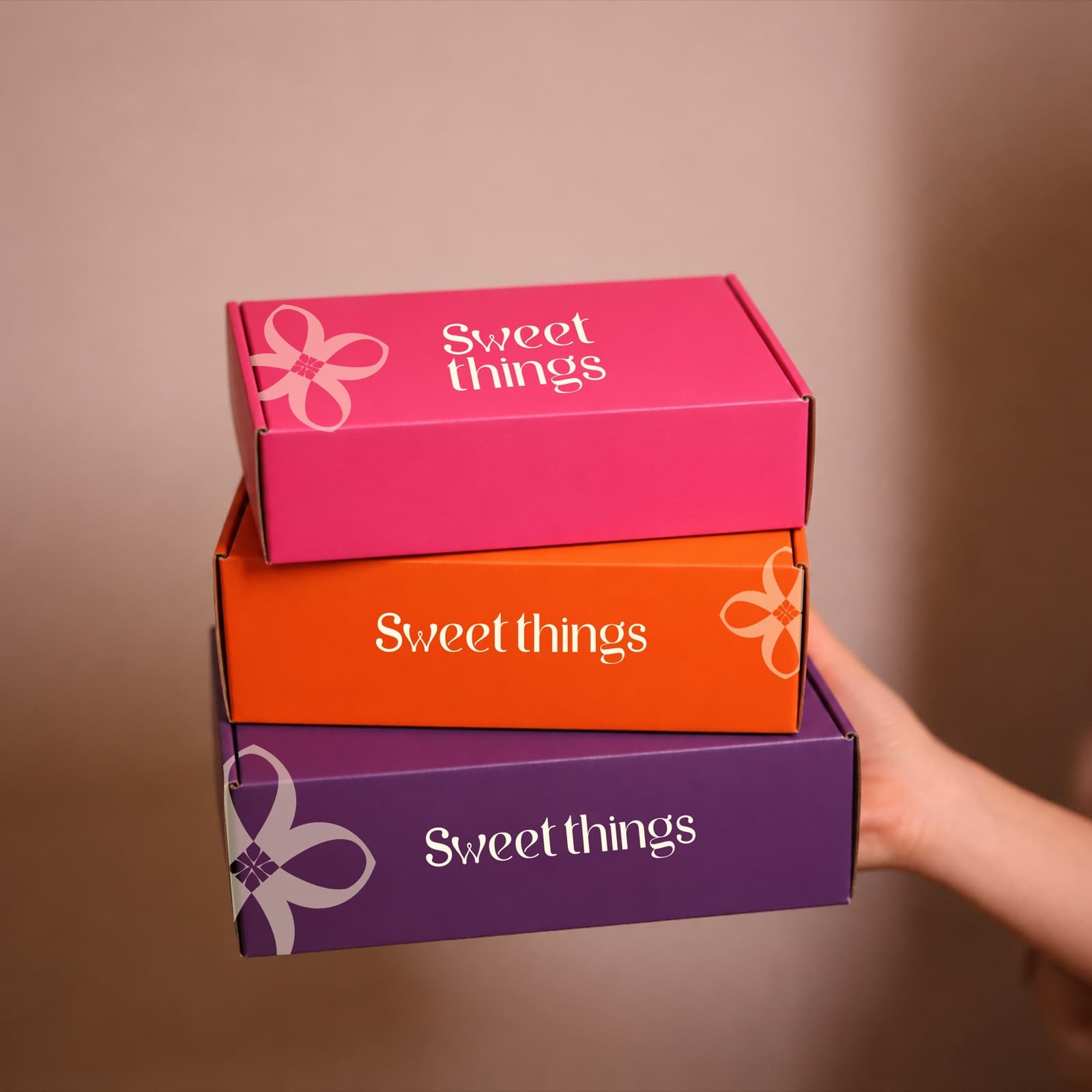 Stacked Sweet Things gift boxes in orange, cerise pink and royal purple